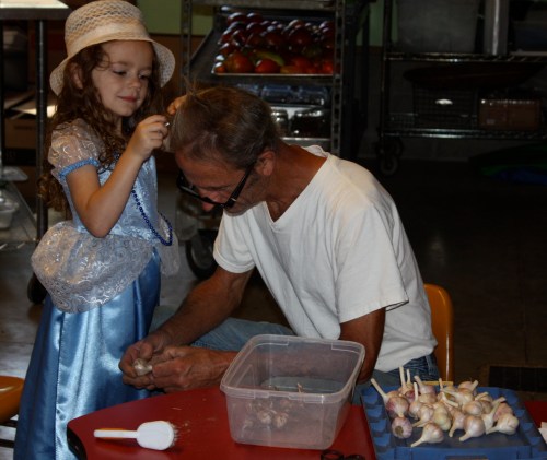 Maeve doing Scott's hair while he cleans the garlic for the salsa mix.