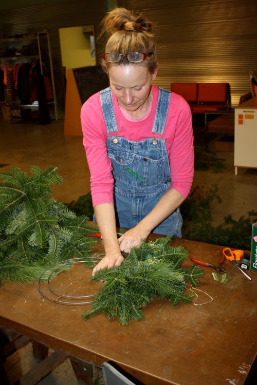 Making holiday evergreen wreaths.